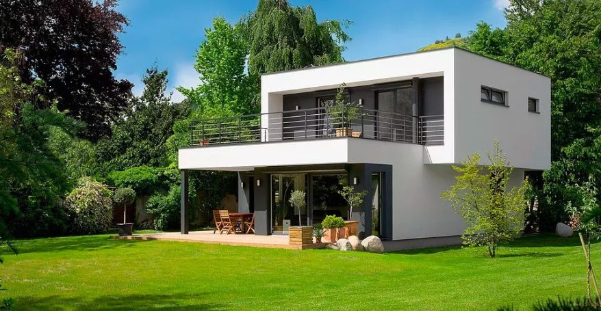 Casa moderna de dos plantas con jardín verde y árboles alrededor. Construcción Steel Frame.